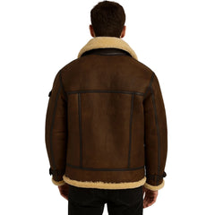 A man viewed from behind wearing a brown leather aviator-style jacket with a cream-colored shearling lining on the collar and hem, paired with black pants against a plain white background.